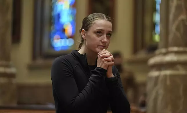Keely Reardon of Chicago kneels with her hands clasped at Holy Name Cathedral, Thursday, May 8, 2025, in Chicago. (AP Photo/Erin Hooley)