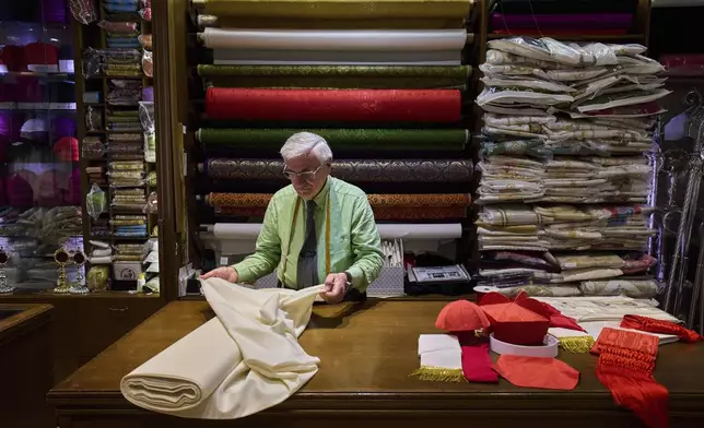 Italian tailor Raniero Mancinelli, 87, prepares the white fabric to create suits, in three different sizes, to be taken to the Vatican in the hope that it might be worn by the new pope, at his shop in Rome, Thursday April 24, 2025. (AP Photo/Bernat Armangue)
