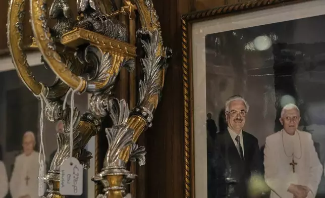 A picture of Italian tailor Raniero Mancinelli and late Pope Benedict XVI hangs inside Mancinelli's shop in Rome, Wednesday, April 30, 2025. (AP Photo/Gregorio Borgia)