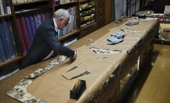 A tailor works at the Gammarelli ecclesiastic clothes tailor shop in Rome, Wednesday, April 30, 2025. (AP Photo/Francisco Seco)