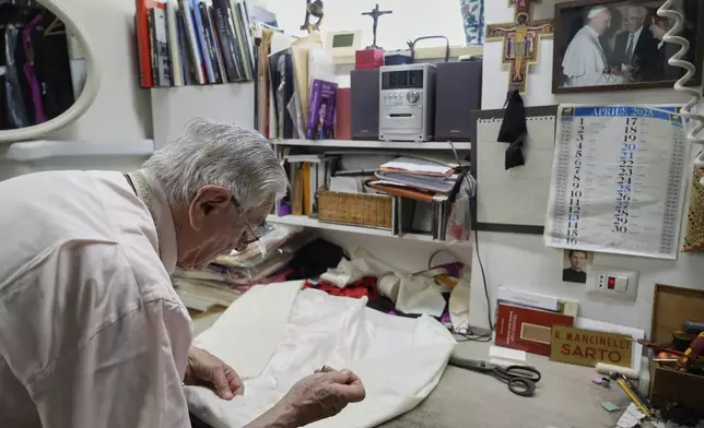 Italian tailor Raniero Mancinelli. who on his own initiative is making outfits for a possible future Pope, works on a pontiff's robe inside his shop in Rome, Wednesday, April 30, 2025. (AP Photo/Gregorio Borgia)