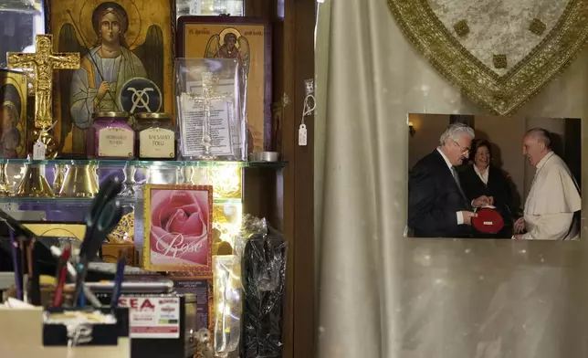 A picture of Italian tailor Raniero Mancinelli and Pope Francis hangs inside Mancinelli's shop in Rome, Wednesday, April 30, 2025. (AP Photo/Gregorio Borgia)