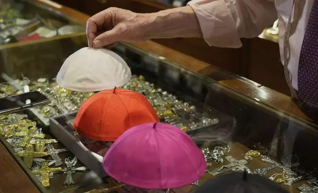 Italian tailor Raniero Mancinelli, who on his own initiative is making outfits for a possible future Pope, shows a pontiff's skull cap as he is interviewed by the Associated Press inside his shop, in Rome, Wednesday, April 30, 2025. (AP Photo/Gregorio Borgia)