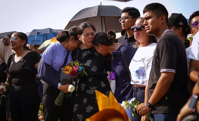 Relatives and friends of Naval Academy Cadet América Yamilet Sánchez, who died aboard a Mexican Navy sailing ship that collided with the Brooklyn Bridge, react during her burial, in Xalapa, Mexico, Tuesday, May 20, 2025. (AP Photo/Victoria Razo)