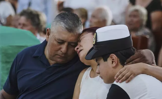 Cosme Sanchez, left, Rocio Hernandez, center, and Anderson Sanchez, family members of Naval Academy Cadet América Yamilet Sánchez, who died aboard a Mexican navy ship that collided with the Brooklyn Bridge, react during her burial, in Xalapa, Mexico, Tuesday, May 20, 2025. (AP Photo/Victoria Razo)