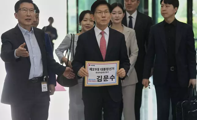 South Korea's People Power Party's presidential election candidate Kim Moon Soo, center, arrives to submit documents to register as a candidate to run in the June 3 presidential election, at the National Election Commission, Gwacheon, South Korea, Sunday, May 11, 2025. The letter read "The 21st Presidential election candidate registration application, Kim Moon Soo."(AP Photo/Ahn Young-joon)