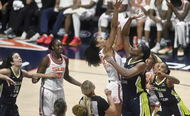 Connecticut Sun's Olivia Nelson-Ododa (10) and Dallas Wing's Arike Ogunbowale (24) reach for a jump ball during a WNBA basketball game Tuesday, May 27, 2025, in Uncasville, Conn. (Sarah Gordon/The Day via AP)