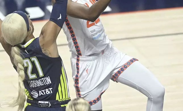 Connecticut Sun's Saniya Rivers (22) puts up a basket from under Dallas Wing's DiJonai Carrington (21) during a WNBA basketball game Tuesday, May 27, 2025, in Uncasville, Conn. (Sarah Gordon/The Day via AP)