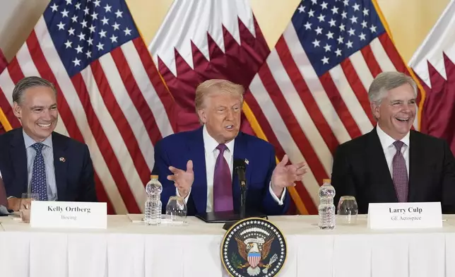 President Donald Trump speaks, seated between Kelly Ortberg President and CEO of Boeing, left, and Larry Culp, CEO of GE Aerospace during a business roundtable, in the presence of Sheikh Saoud bin Abdulrahman bin Hassan bin Ali Al Thani, Deputy Prime Minister and Minister of State for Defense Affairs, Thursday, May 15, 2025, in Doha, Qatar. (AP Photo/Alex Brandon)