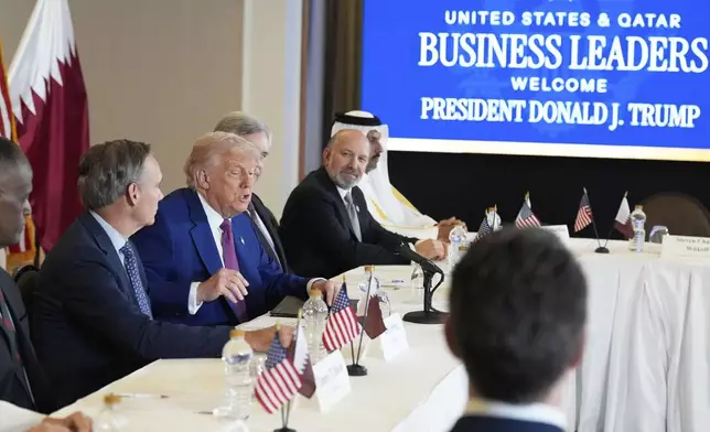 President Donald Trump speaks, seated between Kelly Ortberg President and CEO of Boeing, left, and Larry Culp, CEo of GE Aerospace during a business roundtable, Thursday, May 15, 2025, in Doha, Qatar. (AP Photo/Alex Brandon)