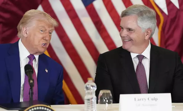 President Donald Trump speaks as Larry Culp, CEO of GE Aerospace smiles during a business roundtable, Thursday, May 15, 2025, in Doha, Qatar. (AP Photo/Alex Brandon)