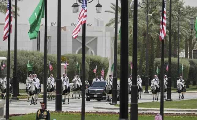 Members of a traditional Saudi honor guard escort the car carrying U.S. President Donald Trump during a welcome ceremony at the Royal Palace in Riyadh, Saudi Arabia, Tuesday, May 13, 2025. (AP Photo/Alex Brandon)