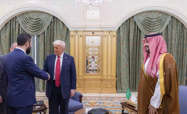 In this photo released by the Saudi Royal Palace, Syria's interim President Ahmad al-Sharaa, left, shakes hands with President Donald Trump, centre, in Riyadh, Saudi Arabia, Wednesday, May 14, 2025. At right is Saudi Crown Prince Mohammed bin Salman.(Bandar Aljaloud/Saudi Royal Palace via AP)