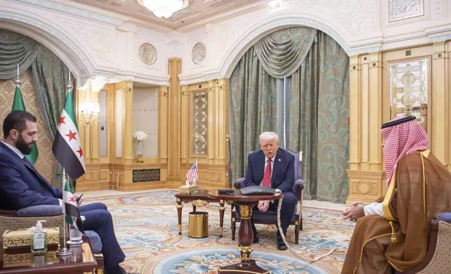 In this photo released by the Saudi Royal Palace, President Donald Trump, centre, meets with Syria's interim President Ahmad al-Sharaa, left, and with Saudi Crown Prince Mohammed bin Salman, right, in Riyadh, Saudi Arabia, Wednesday, May 14, 2025. (Bandar Aljaloud/Saudi Royal Palace via AP)