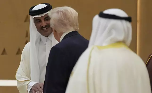 President Donald Trump speaks with Qatar's Emir Sheikh Tamim bin Hamad Al Thani as they arrive to attend a group photo with Gulf Cooperation Council leaders during the GCC Summit in Riyadh, Saudi Arabia, Wednesday, May 14, 2025. (AP Photo/Alex Brandon)
