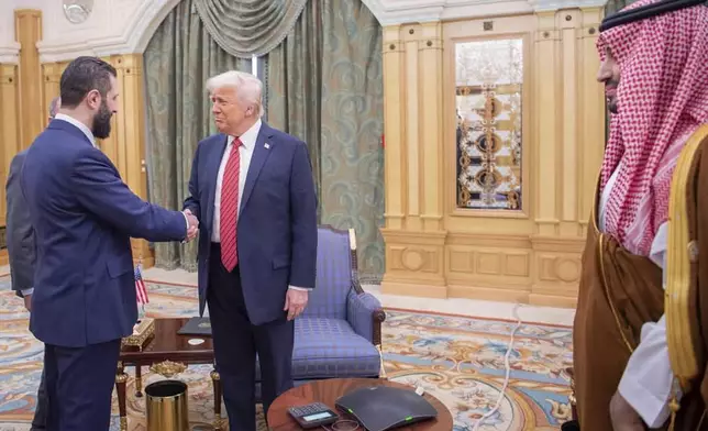 In this photo released by the Saudi Royal Palace, Syria's interim President Ahmad al-Sharaa, left, shakes hands with President Donald Trump, centre, in Riyadh, Saudi Arabia, Wednesday, May 14, 2025. At right is Saudi Crown Prince Mohammed bin Salman.(Bandar Aljaloud/Saudi Royal Palace via AP)