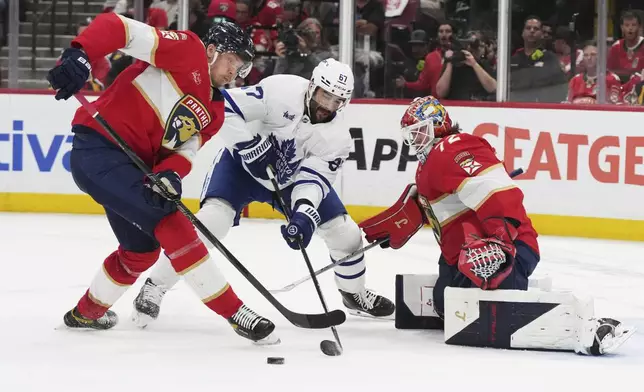 Florida Panthers defenseman Niko Mikkola, left, and Toronto Maple Leafs left wing Max Pacioretty (67) go for the puck as Florida Panthers goaltender Sergei Bobrovsky (72) defends the goal during the second period in Game 6 of a second-round NHL hockey playoff series, Friday, May 16, 2025, in Sunrise, Fla. (AP Photo/Lynne Sladky)