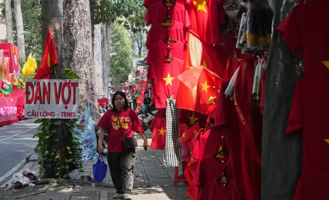 A woman walks after watching a parade celebrating the 50th anniversary of the end of the Vietnam War in Ho Chi Minh City, Vietnam, Wednesday, April 30, 2025. (AP Photo/Achmad Ibrahim)