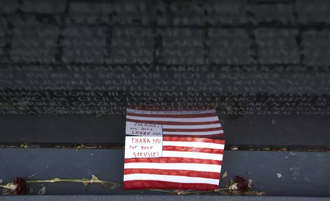 A note thanking veterans is seen at the Vietnam Veterans Memorial on the 50th Anniversary of the fall of Saigon, Wednesday, April 30, 2025, in Washington. (AP Photo/Jacquelyn Martin)