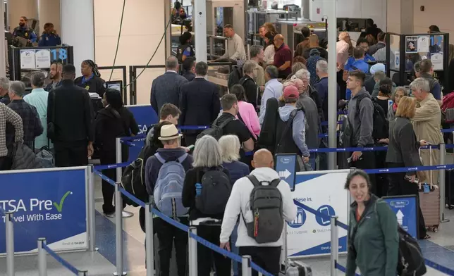 Travelers make their way through security at Newark Liberty International Airport in Newark, N.J., Monday, May 5, 2025. (AP Photo/Seth Wenig)