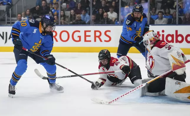 Toronto Sceptres' Sarah Nurse (20) shoots to score a goal while being defended against by Ottawa Charge's Ashton Bell (21) and goaltender Gwyneth Philips (33) during the second period of a PWHL hockey game in Toronto, Saturday, May 3, 2025. (Arlyn McAdorey/The Canadian Press via AP)