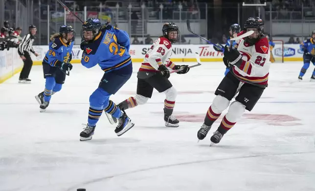 Toronto Sceptres' Sarah Nurse (20) and Ottawa Charge's Shiann Darkangelo (27) skate after the puck during the second period of a PWHL hockey game in Toronto, Saturday, May 3, 2025. (Arlyn McAdorey/The Canadian Press via AP)