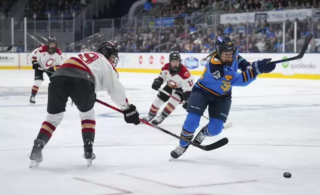 Toronto Sceptres' Renata Fast (14) and Ottawa Charge's Brianne Jenner (19) skate after the puck during the third period of a PWHL hockey game in Toronto, Saturday, May 3, 2025. (Arlyn McAdorey/The Canadian Press via AP)