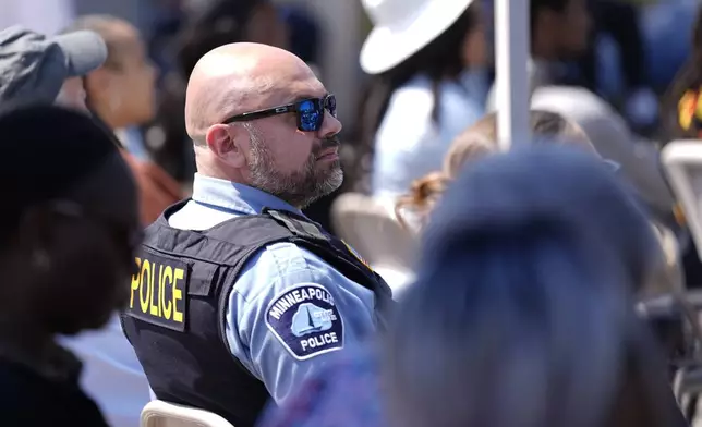 A Police officer attends a prayer service at George Floyd Square on the five-year anniversary of Floyd's death, Sunday, May 25, 2025, in Minneapolis. (AP Photo/Abbie Parr)