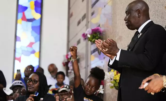Attorney Ben Crump, right, applauds during a memorial service on the anniversary of George Floyd's death on Sunday, May 25, 2025, in Houston. (AP Photo/Ashley Landis)