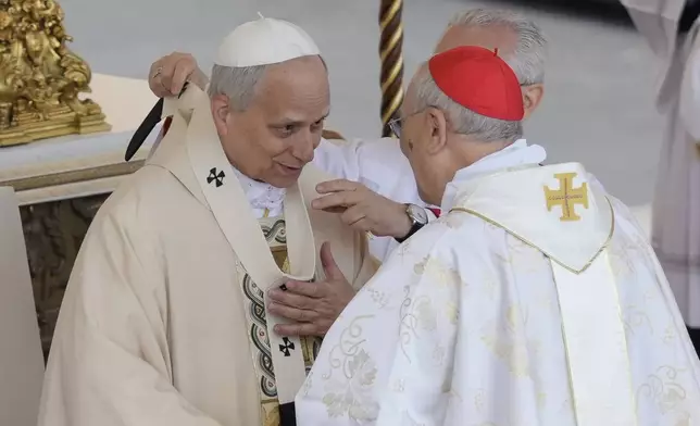 Pope Leo XIV receives the pallium, or lambswool stole, a symbol of the papacy during a Mass for the formal inauguration of Pope Leo XIV's pontificate, in St. Peter's Square, at the Vatican, Sunday, May 18, 2025. (AP Photo/Gregorio Borgia)