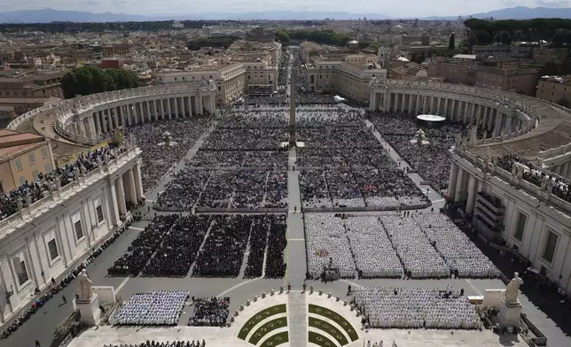 People gather as Pope Leo XIV celebrates a Mass for the formal inauguration of his pontificate, in St. Peter's Square, at the Vatican, Sunday, May 18, 2025. (AP Photo/Alessandra Tarantino)