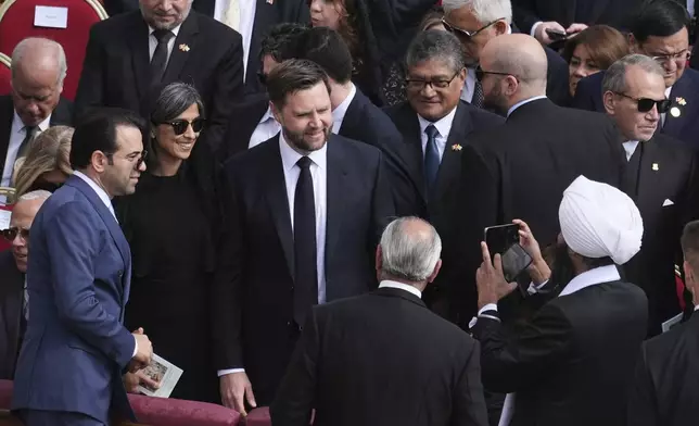 A man takes a mobile phone photo of Vice President JD Vance, center, as he attends the inaugural Mass of Pope Leo XIV's pontificate in St. Peter's Square at the Vatican, Sunday, May 18, 2025. (AP Photo/Jacquelyn Martin, Pool)