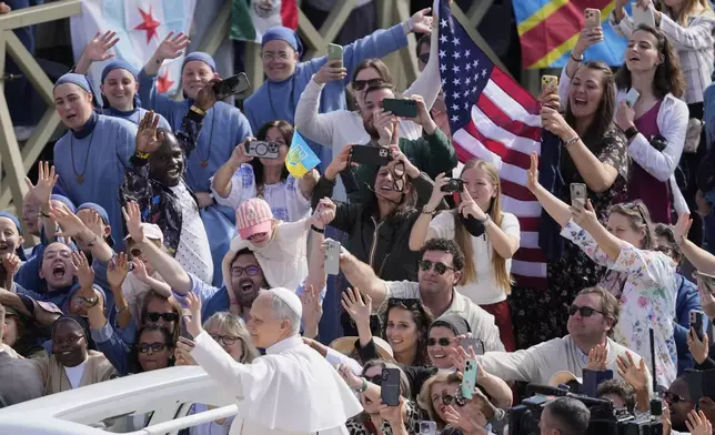 Pope Leo XIV waves from aboard the popemobile as he is driven through the crowd for the formal inauguration of his pontificate with a Mass in St. Peter's Square attended by heads of state, royalty and ordinary faithful, Sunday, May 18, 2025. (AP Photo/Gregorio Borgia)