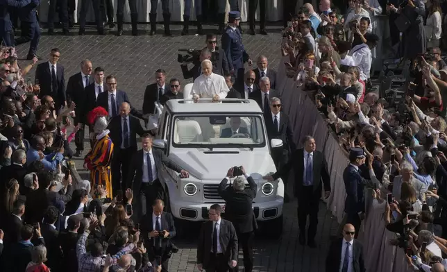 Security surrounds Pope Leo XIV as he arrives aboard the popemobile ahead of a Mass for the formal inauguration of his pontificate, in St. Peter's Square, at the Vatican, Sunday, May 18, 2025.(AP Photo/Gregorio Borgia)