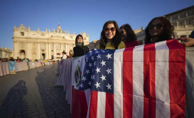 Faithful hold a United States flag ahead of Pope Leo XIV's formal inauguration of his pontificate with a Mass in St. Peter's Square attended by heads of state, royalty and ordinary faithful, Sunday, May 18, 2025. (AP Photo/Andrew Medichini)