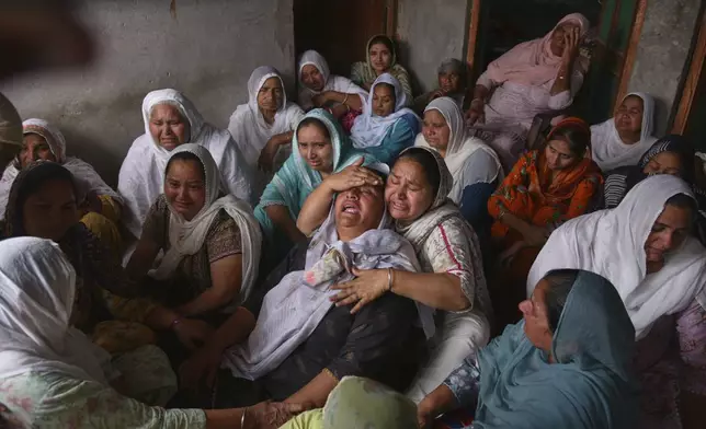 Jabir Kaur, wife of Sukhwinder Singh, center, wails after her husband died consuming toxic liquor, in Majitha village on the outskirts of Amritsar, India, Tuesday, May 13, 2025. (AP Photo/Prabhjot Gill)