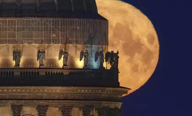The full moon sets behind the St. Isaac's Cathedral in St. Petersburg, Russia, early Tuesday, May 13, 2025. (AP Photo/Dmitri Lovetsky)