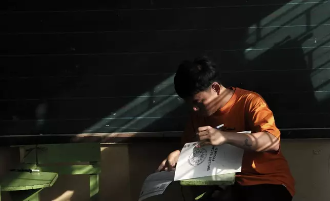 A man prepares to cast his ballot at a polling station in Quezon City, Philippines, Monday, May 12, 2025. (AP Photo/Basilio Sepe)