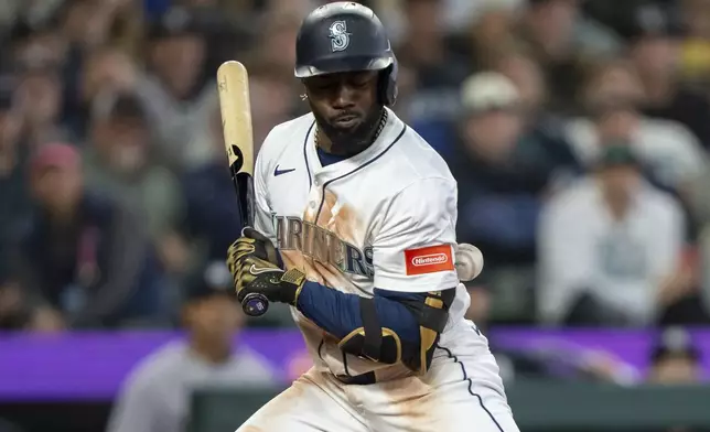 Seattle Mariners' Randy Arozarena is hit by a pitch during the eighth inning of a baseball game against the New York Yankees, Wednesday, May 14, 2025, in Seattle. (AP Photo/Stephen Brashear)