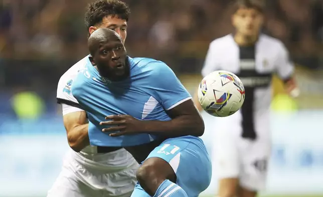 Napoli's Romelu Lukaku, foreground and Parma's Alessandro Circati vie for the ball during a Serie A soccer match between Parma and Napoli at Parma's Ennio Tardini Stadium, Italy, Sunday, May 18, 2025. (Gianni Santandrea/LaPresse via AP)