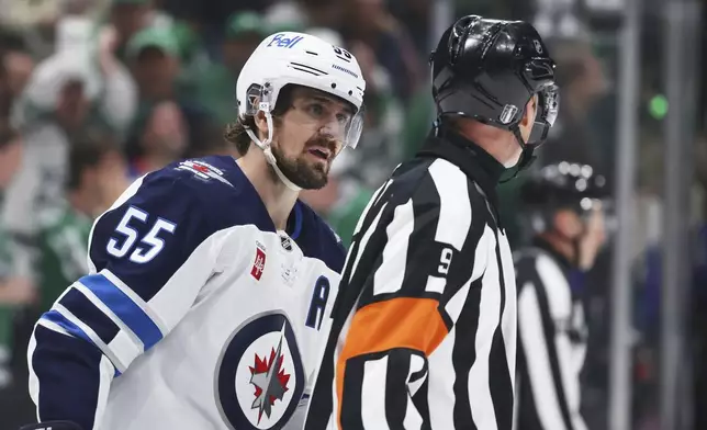 Winnipeg Jets' Mark Scheifele (55) talks to referee Dan O'Rourke (9) after Scheifele was issed a tripping penalty in the third period of Game 6 of a second-round NHL hockey playoff series against the Dallas Stars in Dallas, Saturday, May 17, 2025. (AP Photo/Gareth Patterson)