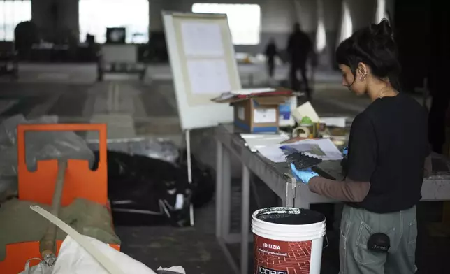 A set designer prepares paint for a stage canvas in the "Teatro dell' Opera" opera house warehouse, in Rome, Thursday, April 10, 2025. (AP Photo/Andrew Medichini)