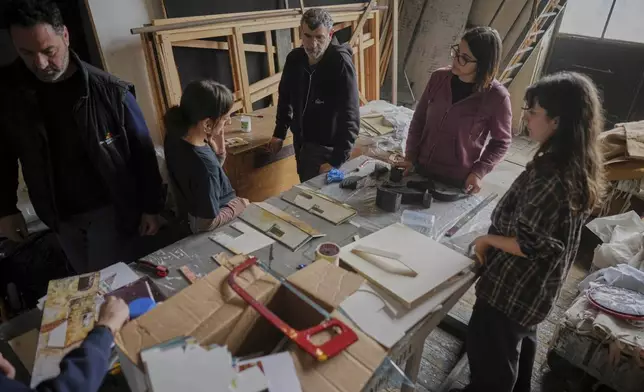 Danilo Mancini, director of set production, left, oversees designers as they work on the project of stage canvases in the "Teatro dell' Opera" opera house warehouse, in Rome, Thursday, April 10, 2025. (AP Photo/Andrew Medichini)