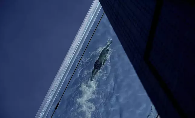 A man swims in the Sky Pool on a sunny day in London, Thursday, May 1, 2025. (AP Photo/Kin Cheung)