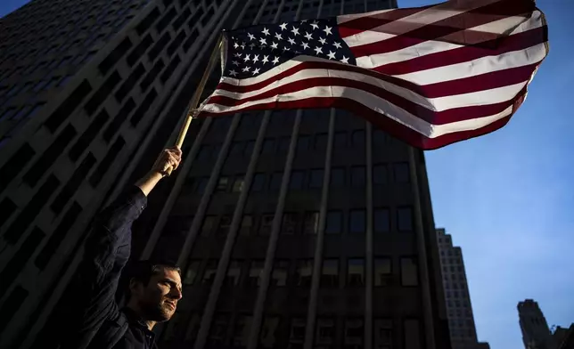 Thomas Slater waves an American flag during the NYCLU's May Day rally for workers and immigrants' rights, Thursday, May 1, 2025, in New York. (AP Photo/Angelina Katsanis)