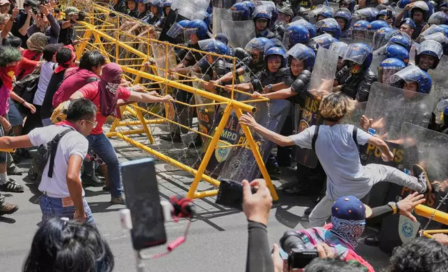 Activists and workers scuffle briefly with police as they tried to remove the barricades during a May Day rally near the Malacanang presidential palace in Manila, Philippines on Thursday, May 1, 2025. (AP Photo/Aaron Favila)