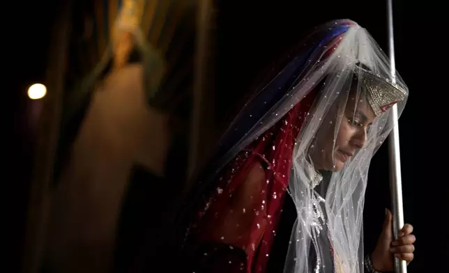 An Order of the Sunrise follower attends an annual ceremony known as the "Day of the Spiritual Indoctrinator," at the group's lakeside temple in Planaltina, Brazil, Thursday, May 1, 2025. (AP Photo/Eraldo Peres)