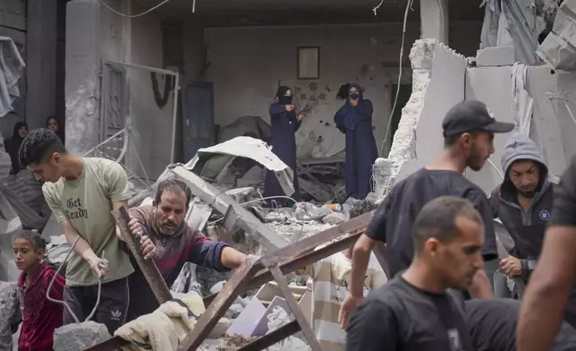 Palestinians search the rubble of a house targeted by an Israeli army strike that killed killing at least five members of the Abu Sahloul family in Khan Younis, in the southern Gaza Strip, Thursday, May 1, 2025. (AP Photo/Abdel Kareem Hana)