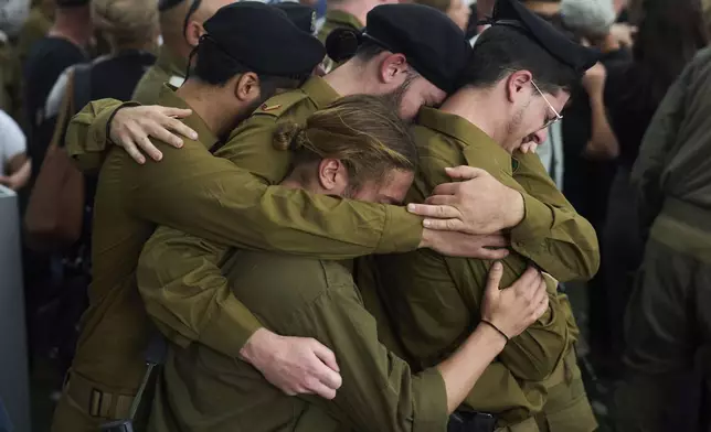 Israeli soldiers mourn reservist Master sergeant Asaf Cafri, 26, who was killed in Israel's ground operation in the Gaza Strip, during his funeral, in Gezer regional council, Israel, Sunday, April 27, 2025. (AP Photo/Ariel Schalit)