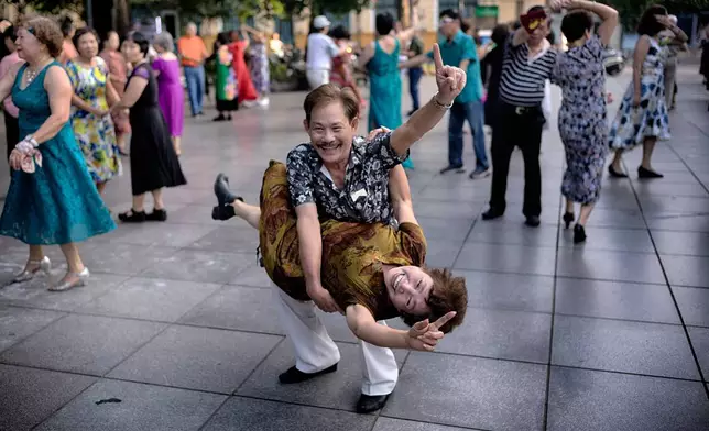 A Vietnamese couple practice Ballroom dancing as part of their morning exercise along Hoan Kiem Lake in Hanoi, Vietnam on Friday, May 2, 2025. (AP Photo/Richard Vogel)